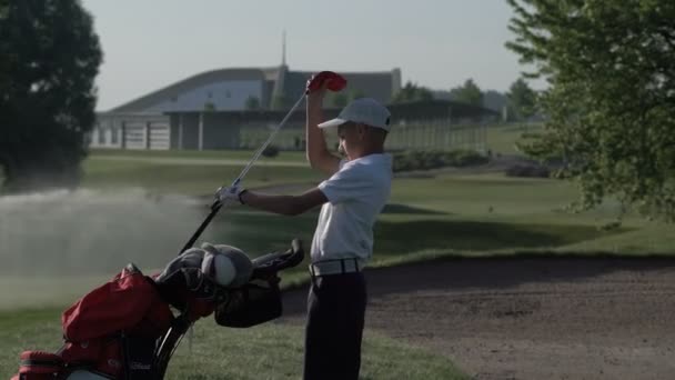 Juniorgolfer spielt im Sommer Golf mit Schlagschlag auf grünem Gras — Stockvideo