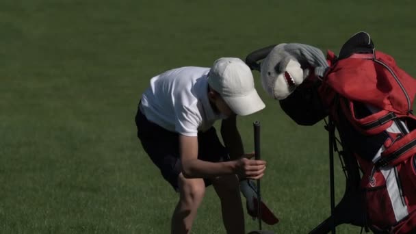 Junior golfare spela golf på sommaren med att slå skott på grönt gräs — Stockvideo