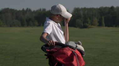 Junior golfçü yaz yeşil çim üzerinde atış isabet ile golf oynamak