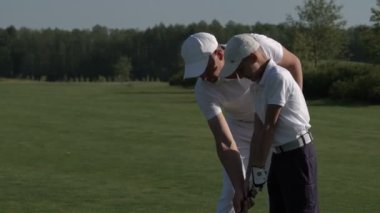 Mükemmel golf sahasında yaz gününde yürüyüş onun oğlu golfçüler ile mutlu adam