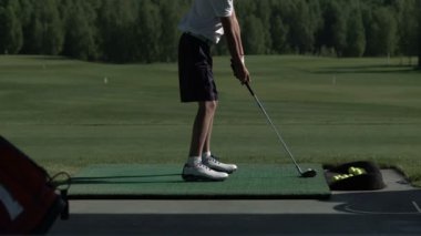 Genç Golf driving range, yan görünümden üzerinde onun golf salıncak uygulamaları