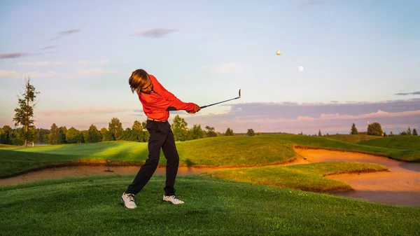 12-vuotias poika golfaamassa golfkentällä — kuvapankkivalokuva