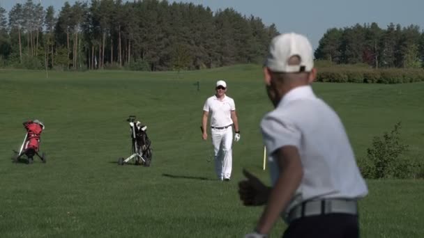 Homem feliz com seu filho golfistas andando no campo de golfe perfeito no dia de verão — Vídeo de Stock