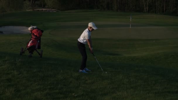 Šťastný chlapec golfista. Veselé dětské chlapce na golfovém hřišti při západu slunce — Stock video