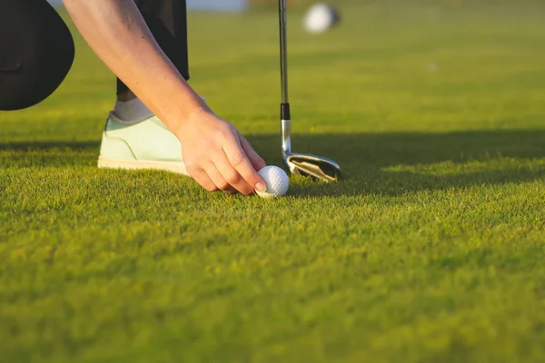 Mão colocando bola de golfe no tee — Fotografia de Stock