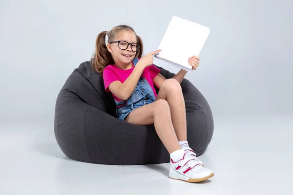 Joven chica bonita de la escuela sosteniendo libro blanco — Foto de Stock