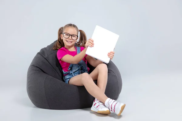 Joven chica bonita de la escuela sosteniendo libro blanco — Foto de Stock