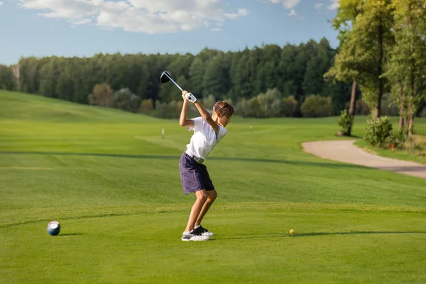 Chico jugando golf, makigng tiro desde el tee — Foto de Stock