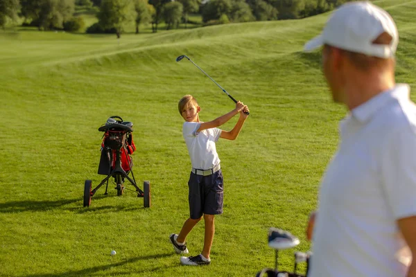 11 anos de idade menino praticar golpes de golfe no campo de golfe — Fotografia de Stock