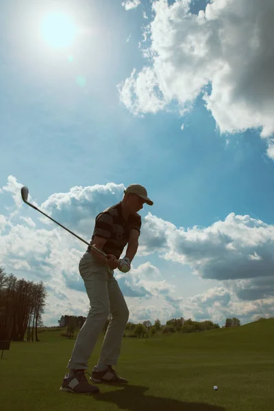 Hombre jugando al golf y golpeando una pelota de golf en un día soleado — Foto de Stock