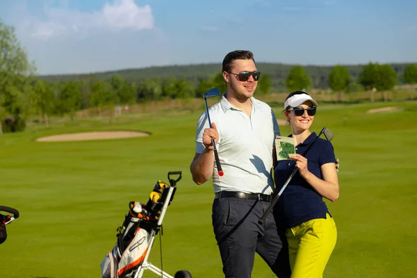 Genç kadın ve erkekler oynarken golf güneşli gün — Stok fotoğraf