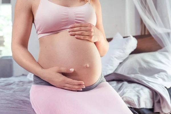 Gravid kvinna vidrör magen närbild — Stockfoto