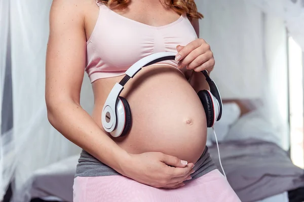 Gravid Kvinna Använda Hörlurar Hennes Mage — Stockfoto