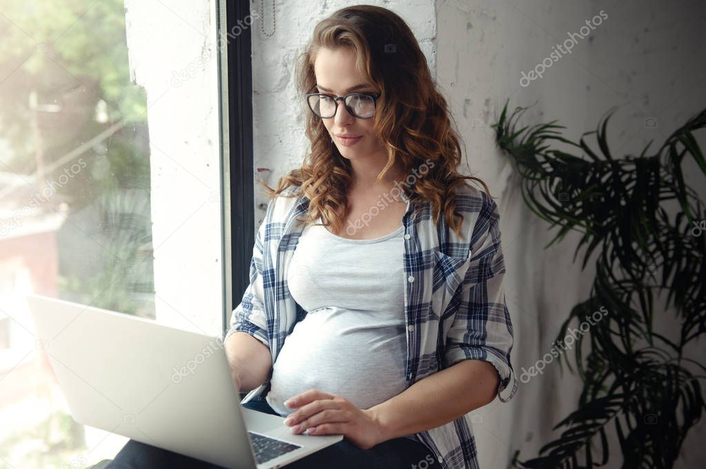 Pregnant woman use of laptop computer for working at home