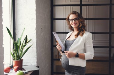 Ofiste çalışan hamile, olgun bir iş kadını.