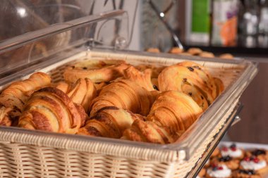 Pastanede örgü ören bir sepetteki kruvasanlar..