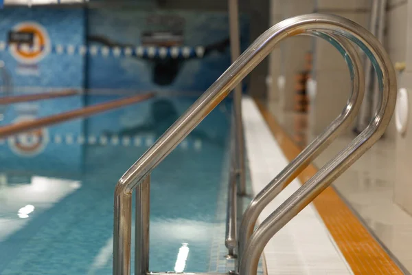Soft focused picture of stainless steel Stairs down to the pool,with Reflection in the pool