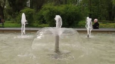 Parkta çeşme. Su karaba§ ve parkta bir bahar güneşli bir günde çocuklar. Şeffaf suyu temizleyin. Şehir su yolunda su gürültüsü.