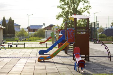 Güzel bahçesi anaokulunda kırmızı kiremit çatı ve çok renkli düşük çit, yeşil çim, değişim, slaytlar ve kum ile parlak yeni kameriye. Çocuk Aktiviteleri açık havada için mükemmel bir yer.