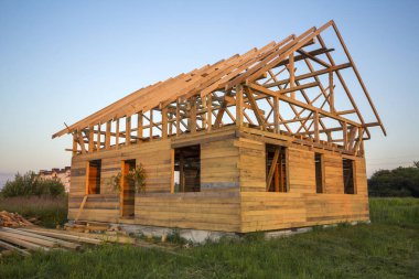 Yeni yazlık doğal ekolojik kereste malzeme yapım aşamasında yeşil alan. Ahşap duvarlar ve dik çatı çerçeve. Özellik, yatırım, profesyonel yapı ve imar kavramı.