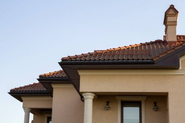 Geniş kahverengi shingle çatı modern lüks pahalı konut yazlık evin üç bacalar, büyük pencereler ve oluk boru ile kapatın. İnşaat, satış, satın alma ve ipotek kavramı.