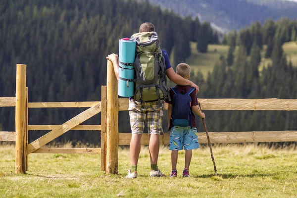 Vater Und Sohn Mit Touristenrucksäcken Niedrigen Holzzaun Auf Grünen Bergen — Stockfoto