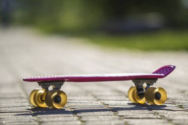 Yakın çekim çocuk plastik pembe parlak beyaz ve yeşil bulanık bokeh arka plan üzerinde izole kaldırım kaykay. Spor, eğlence, eğlenceli ve çalış kavramı.