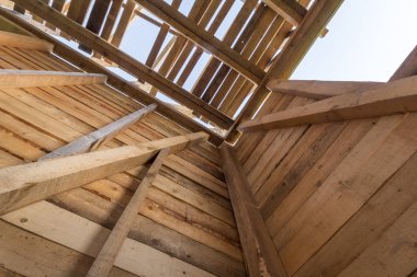 Yeni ahşap ev yapım aşamasında. Duvar ve çatı çerçevesinden içinde açık gökyüzü karşı yakın çekim. Doğal malzemelerin ekolojik rüya ev. Yapı, inşaat ve yenileme kavramı.