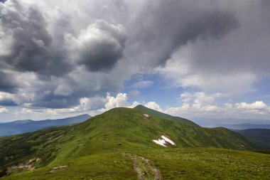 Sabah güneş yeşil vadi, orman ve uzak sisli dağlar yamalar rüzgarlı bulutlu gökyüzü altında kar ile kaplı tepeler tarafından geniş Panoraması yaktı. Güzellik, Doğa, turizm ve seyahat kavramı.
