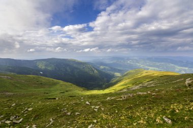 Sabah güneş yeşil vadi, orman ve uzak sisli dağlar yamalar rüzgarlı bulutlu gökyüzü altında kar ile kaplı tepeler tarafından geniş Panoraması yaktı. Güzellik, Doğa, turizm ve seyahat kavramı.