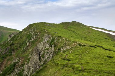Sabah güneş geniş yeşil vadi tarafından yaktı, tepeler çim kaplı ve uzak dağ kayaların altında parlak mavi gökyüzü yaz ve kabarık beyaz bulutlar. Güzellik, Doğa, turizm ve seyahat kavramı.