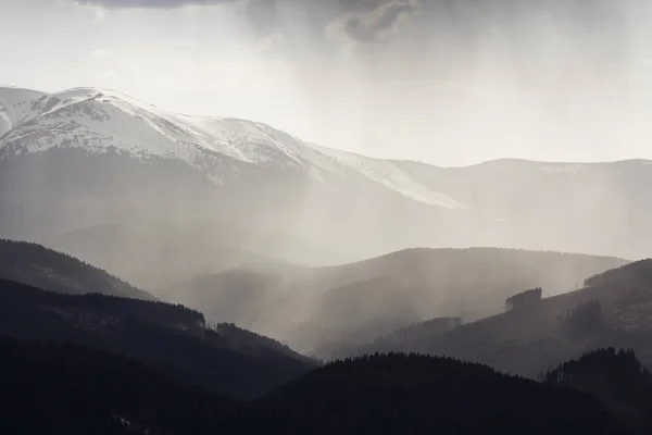 壮丽的景色 壮观的雾气缭绕的山脉 覆盖着永远绿色的森林在朦胧的宁静的早晨或黄昏下的黑暗多云的天空 山顶上覆盖着积雪的距离 — 图库照片