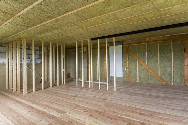 Yapım ve yenileme büyük geniş meşe zemin, duvar ve tavan taş yünü ve soğuk bariyer için cam elyaf ve gelecekteki duvarlar için ahşap çerçeve ile bitmemiş tavan arası Oda boş.