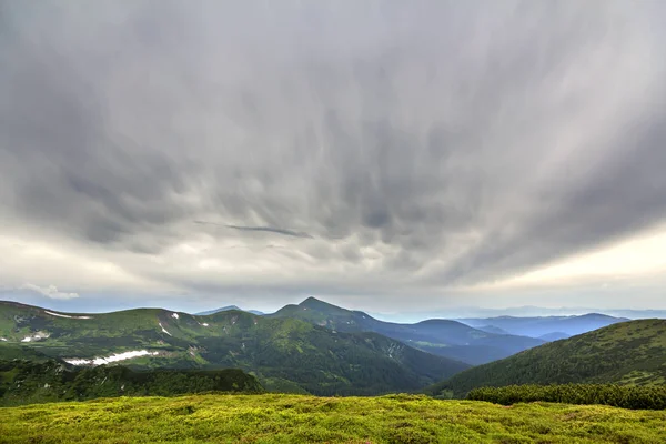 Sabah güneş yeşil vadi, orman ve uzak sisli dağlar yamalar rüzgarlı bulutlu gökyüzü altında kar ile kaplı tepeler tarafından geniş Panoraması yaktı. Güzellik, Doğa, turizm ve seyahat kavramı.