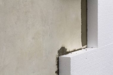 Sert köpük yalıtım ile sıvalı ev duvar detay yakın çekim. Modern teknoloji, inşaat, tadilat, enerji tasarrufu, alternatif mineral yün, sıcak rahat ev kavramı için.