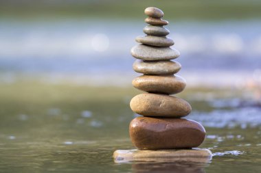 Piramit kazık landmark bulanık mavi-yeşil puslu kopya alanı zemin üzerine sığ suda gibi ıslak sert doğal kahverengi düzensiz farklı boyut ve formlar taş yakın çekim soyut resim dengeli.