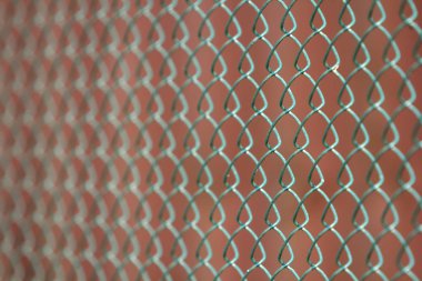 İzole boyalı basit geometrik siyah demir metal tel zincir bağlantı çit eon koyu kırmızı zemin Close-up. Çit, koruma ve muhafaza kavramı.