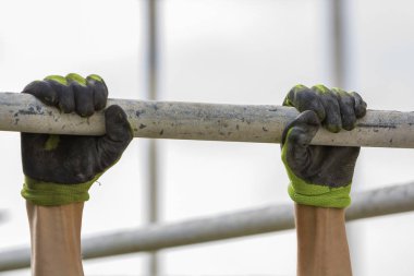 Kaslı alt Close-up iskele metal boru poliüretan köpük sayfa arka planı ile Beyaz Saray duvarda asılı eller. Modern teknoloji, yenileme, izolasyon, profesyonel iş kavramı.