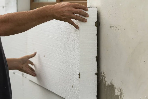 労働者の手塗られたレンガの壁のインストールの白い硬質ウレタン シート 現代の技術 断熱の概念 — ストック写真