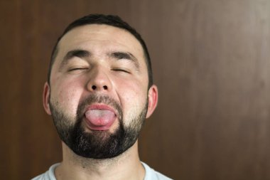 Portre yakışıklı siyah saçlı akıllı modern genç adam tür siyah arka plan üzerinde bulanık gülümseyen gözleri ve kısa saç kesimi bardaklarda sakallı. Gençlik ve güven kavramı.