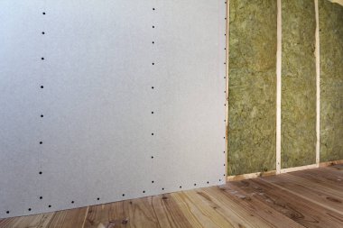 Alçıpan plakalar ile gelecekteki duvarlar için ahşap çerçeve kaya yünü ve fiberglas ile yalıtım personel soğuk bariyer için yalıtılmış. Rahat sıcak ev, ekonomi, inşaat ve tadilat kavramı.