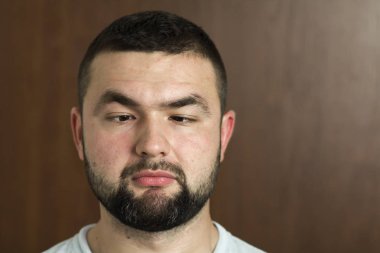 Portre yakışıklı siyah saçlı akıllı modern genç adam tür siyah arka plan üzerinde bulanık gülümseyen gözleri ve kısa saç kesimi bardaklarda sakallı. Gençlik ve güven kavramı.