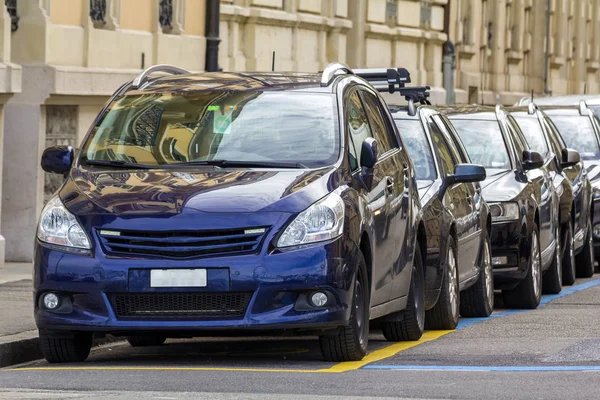 新しい光沢のある高価な車の長い列は 大きな石造りの明るい日当たりの良い夏や春の日の建物できれいな空街に沿って駐車 現代のライフ スタイル 駐車場問題のコンセプト — ストック写真