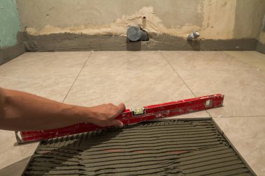 Seramik kiremit ve çatı ustası için araçlar. İşçi el yükleme yer karosu. Ev geliştirme, yenileme - Seramik Karo döşeme yapıştırıcı, harç, düzeyi.