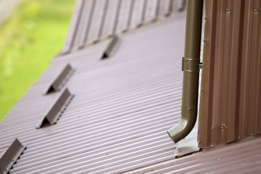 Kahverengi yeni cilt payı metal sistem boru bulanık kopya alan arka plan üzerinde Close-up. Duvardaki çatı binadan yağmur suyu drenaj için dikey inşaat. Drenaj koruma, profesyonel çalışma.