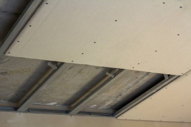 Yakın çekim detayını Oda yapım aşamasında. Asma tavan Alçıpan vidaları ile metal çerçeve için sabit üzerinden. Yenileme, izolasyon, konfor, profesyonel iş ve kavram kendin yap.