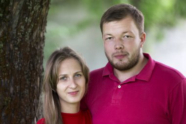 Yakın çekim Genç çekici mutlu romantik gülümseyen çift sevgi, sarışın uzun saçlı kız ve yakışıklı tıraşsız adam birlikte açık havada sarılma parlak güneşli arka plan bulanık üzerinde portresi.