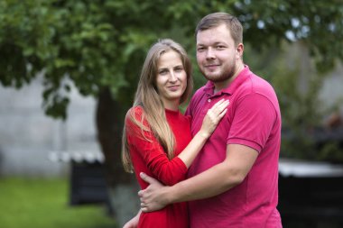 Yakın çekim Genç çekici mutlu romantik gülümseyen çift sevgi, sarışın uzun saçlı kız ve parlak bulanık güneşli yaz kırsal arka plan açık havada yakışıklı tıraşsız adam portresi.