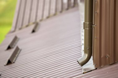 Kahverengi yeni cilt payı metal sistem boru bulanık kopya alan arka plan üzerinde Close-up. Duvardaki çatı binadan yağmur suyu drenaj için dikey inşaat. Drenaj koruma, profesyonel çalışma.