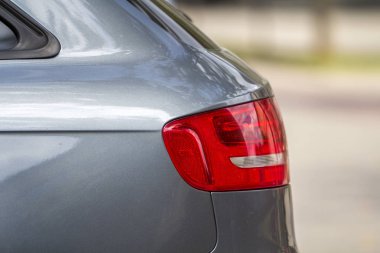 Modern ulaşım tasarım, güvenlik, sürüş ve motorlu araç konsepti - yan görünümü detay yeni parlak lüks gümüş renkli araba bulanık parlak yaz Kopyala uzay arka plan üzerinde kırmızı dur ışıkları kapat.